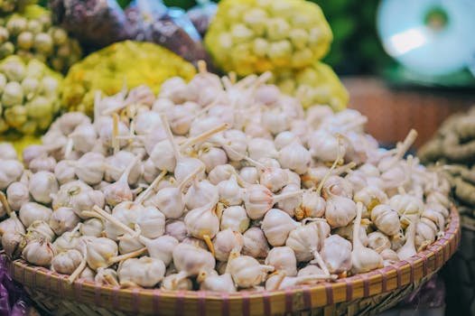 A large pile of fresh garlic bulbs on display at a local market, ready for sale.