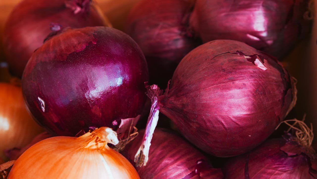 Vivid close-up shot of organic red and yellow onions with natural texture in a basket.